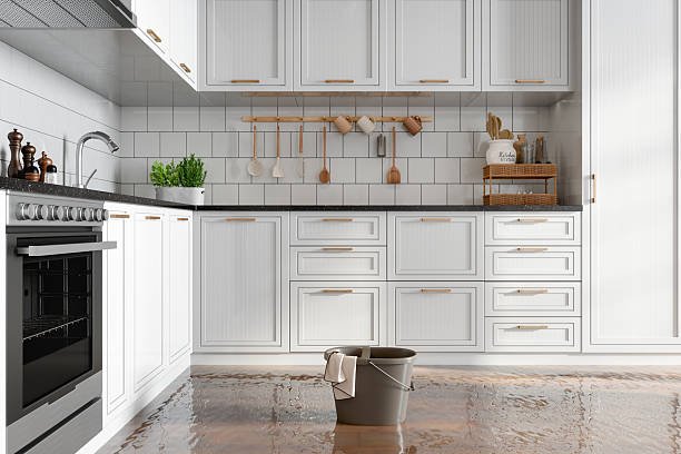Flooded Kitchen With A Cleaning Bucket On The Floor